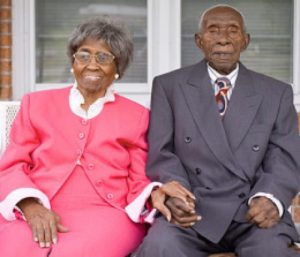 older couple sitting holding hands