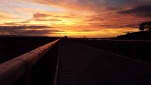 a sunset overlooking a boardwalk