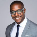 corporate headshot of a man in suit and glasses